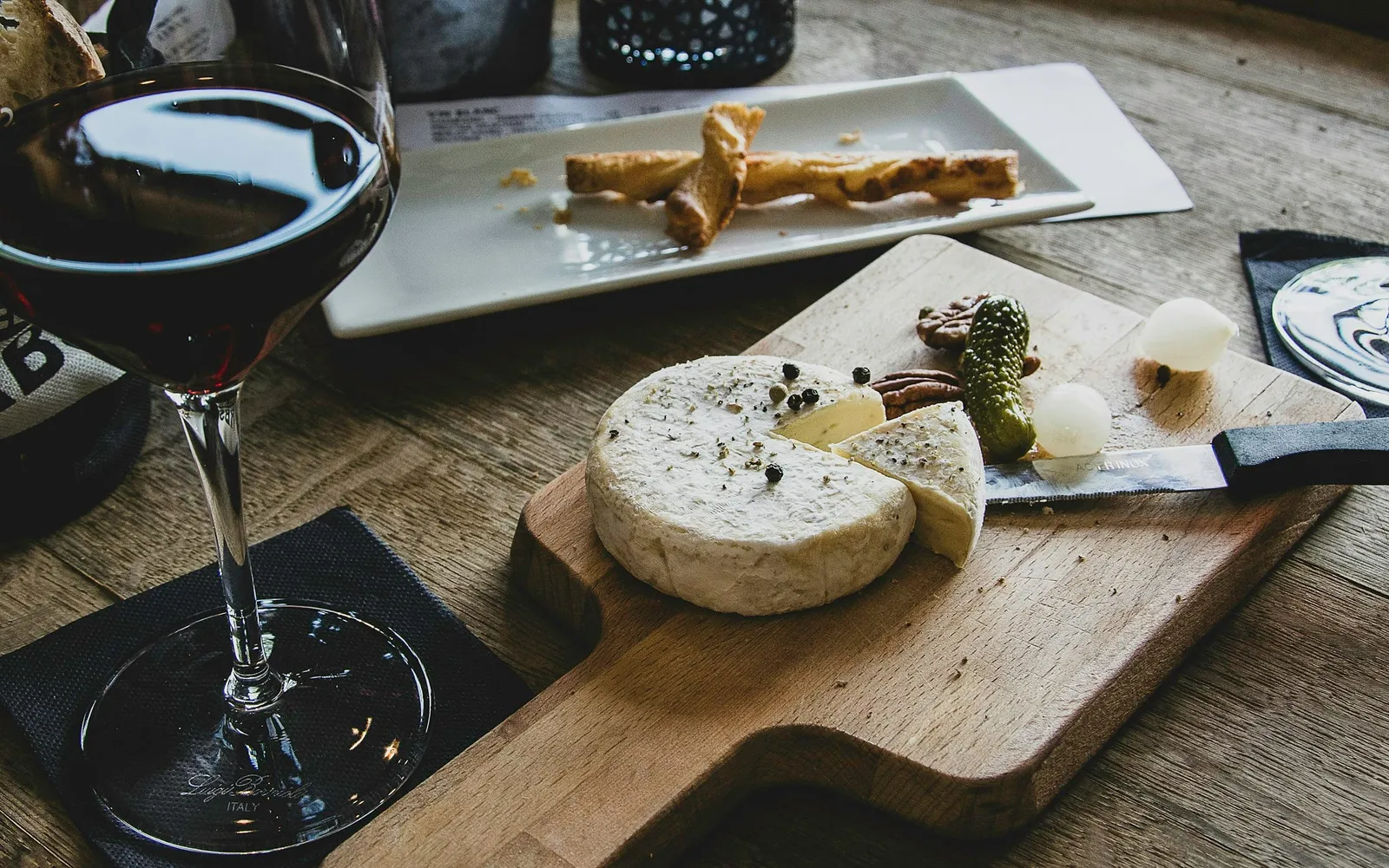 Fromages, pain, raisin et verre de vin sur une table